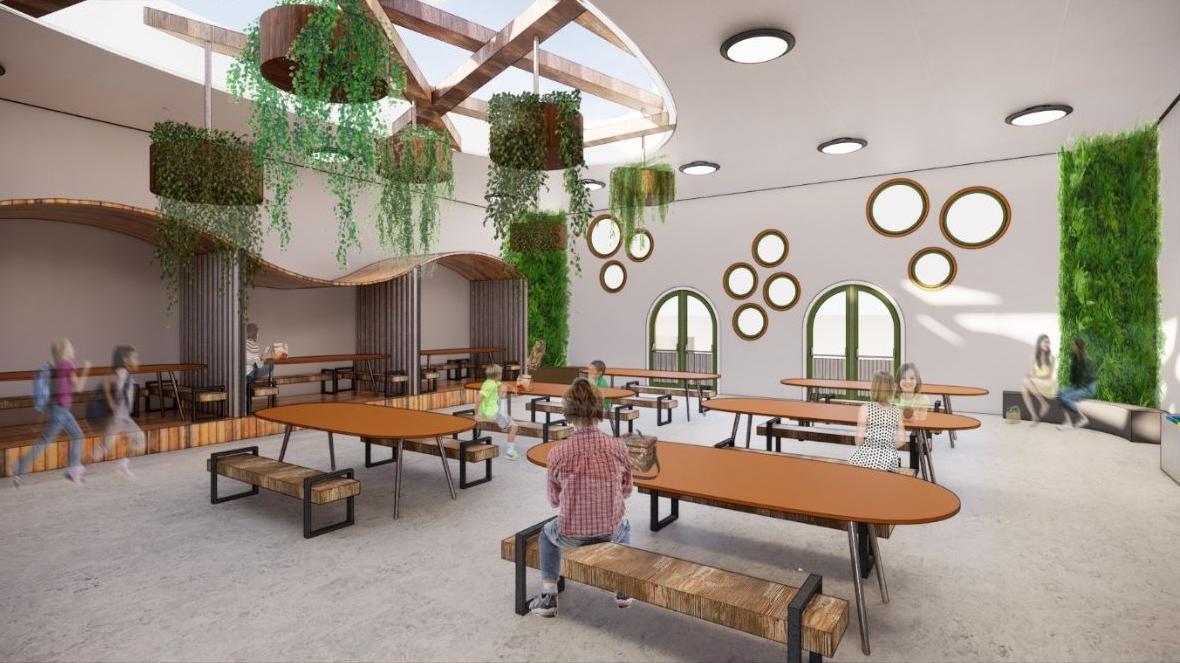 A rendering of a school cafeteria with oval tables 和 hanging plants.
