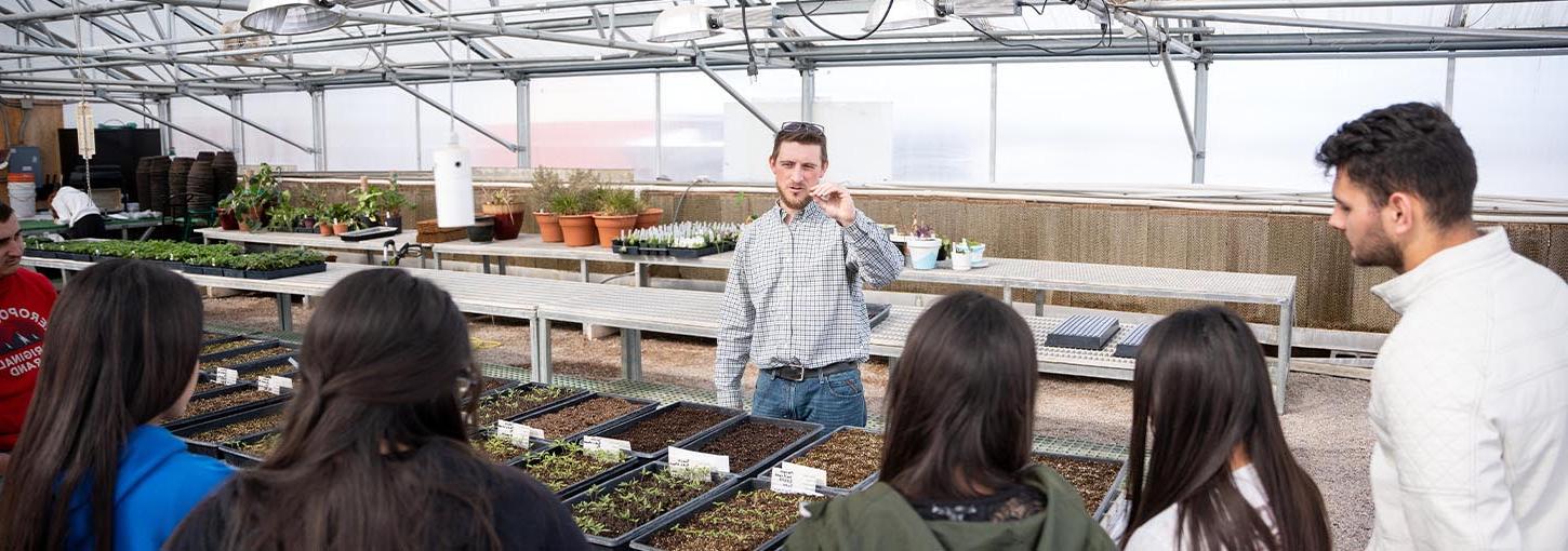 A group of people in a greenhouse.