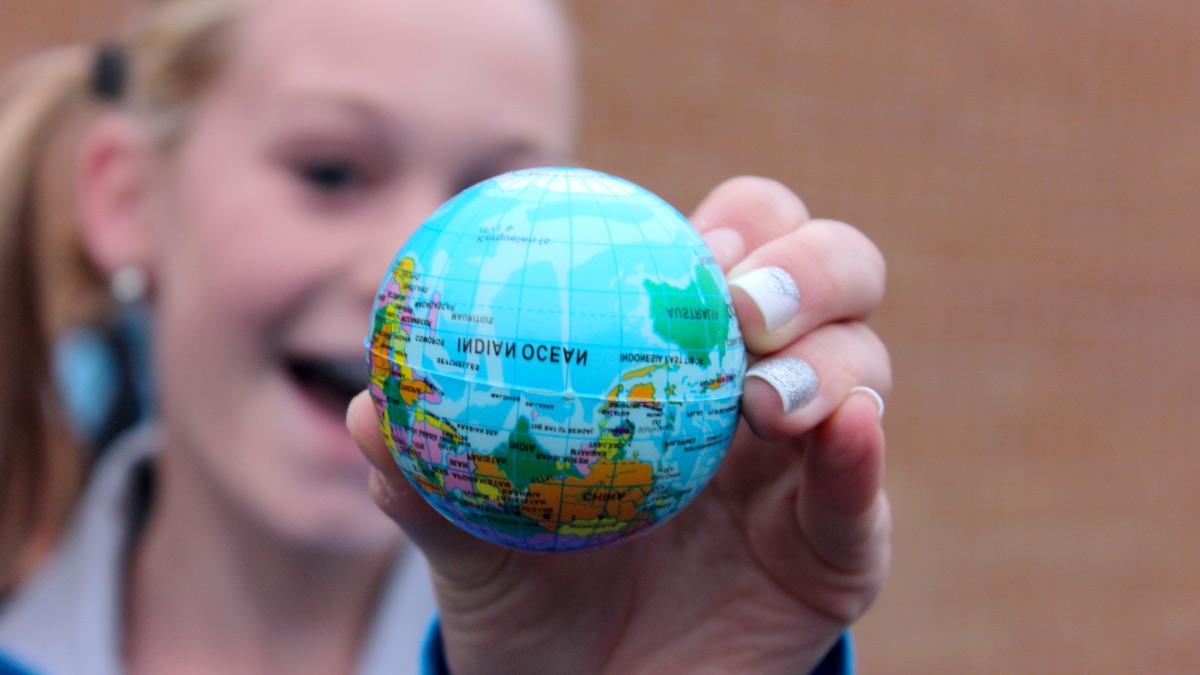 A small globe held by a girl upside down with Indian Ocean facing camera